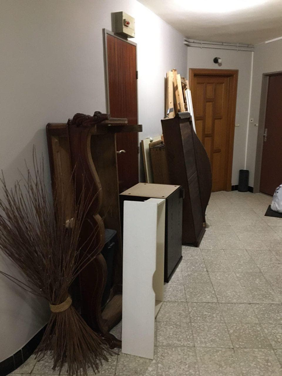 Couloir d'immeuble encombré de mobilier avant intervention