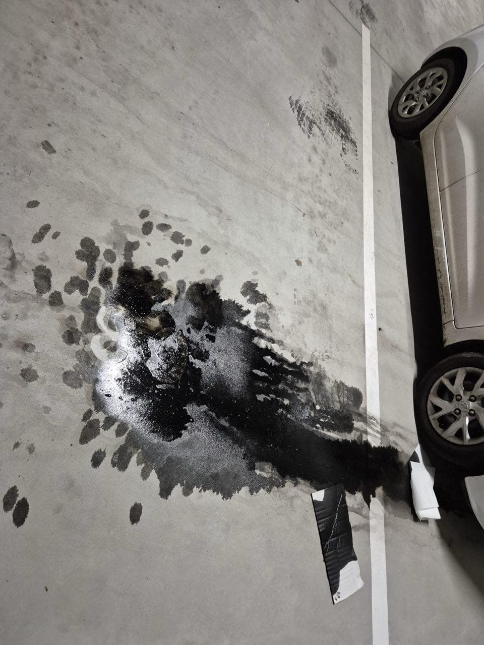 Emplacement de parking taché de mazout avant nettoyage à Charleroi